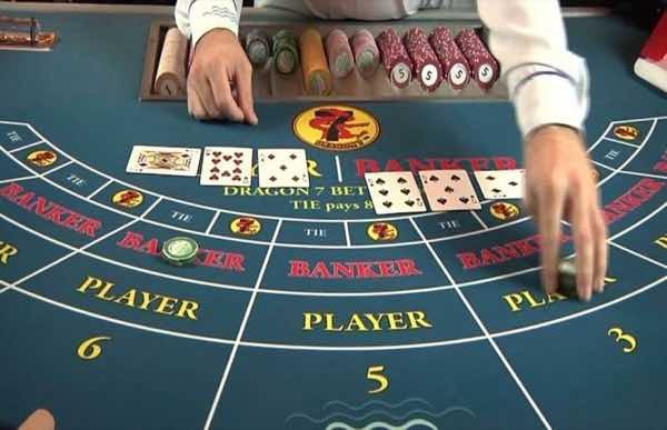 Croupier dealing cards at a baccarat table, with Banker and Player sections and chips nearby.